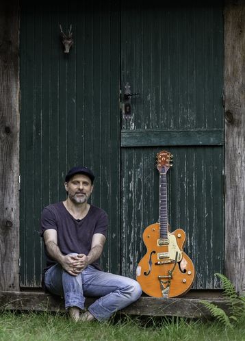 Kalostrape Ostatua Jatetxea, Baiona, Euskal Herria. Bar restaurant du Petit Bayonne, situé dans l'ancien cloitre des Visitandines. Bar et restaurant de l'école de basque pour adultes, AEK. Photo de promotion du chanteur Xabi San Sebastian, il pose devant une porte verte, assis à côté de sa guitare.