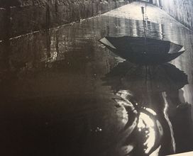 Kalostrape Ostatua, Jatetxea - Baiona Euskal Herria. Bar restaurant situé dans l'ancien cloitre des Visitandines, au coeur du Petit Bayonne. Concerts et soirées. Expositions du mois d'octobre 2017, avec Mathieu Prat. Photographie en noir et blanc, gros plan sur un parapluie flottant sur les inondations de Bayonne.